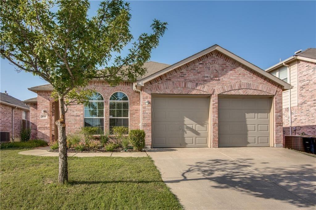 View of front of home featuring an attached garage, brick siding, and driveway