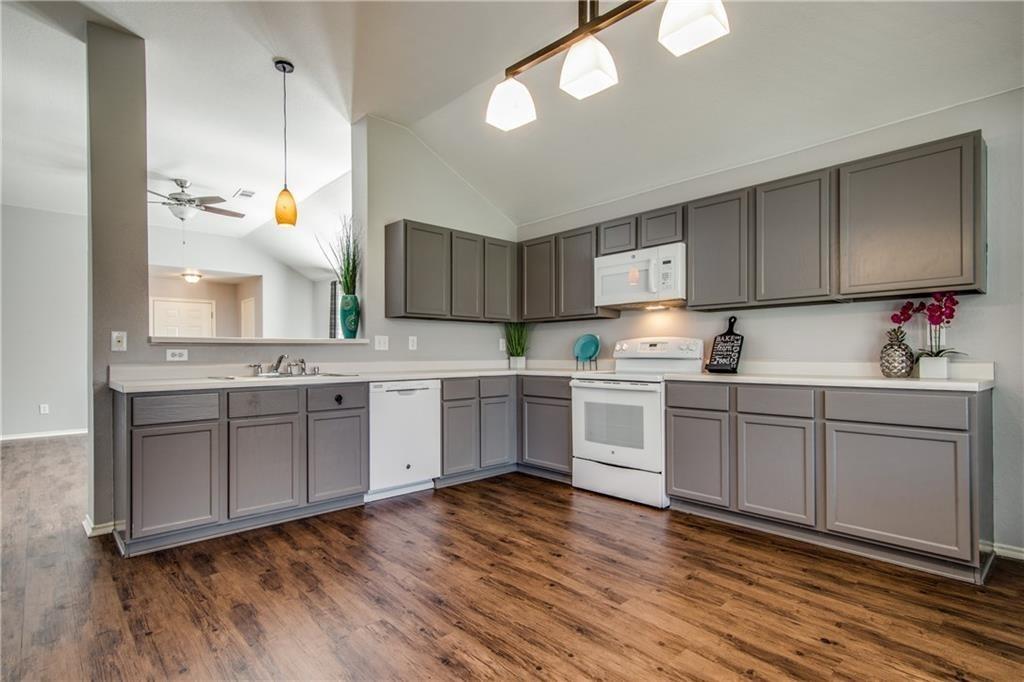 3608 Diamond Ranch Road Fort Worth, TX 76262 - Photo 6 of 13 Kitchen featuring light countertops, white appliances, decorative light fixtures, gray cabinets, and lofted ceiling