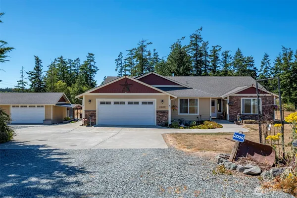 a front view of a house with a yard and trees