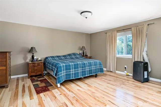 a bedroom with a bed and wooden floor