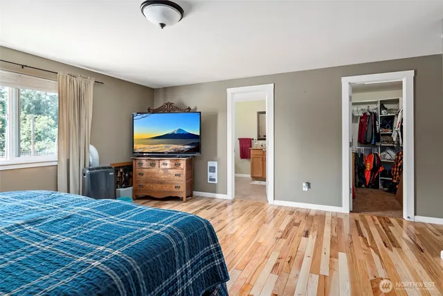 a bedroom with a bed and a flat tv screen on dresser