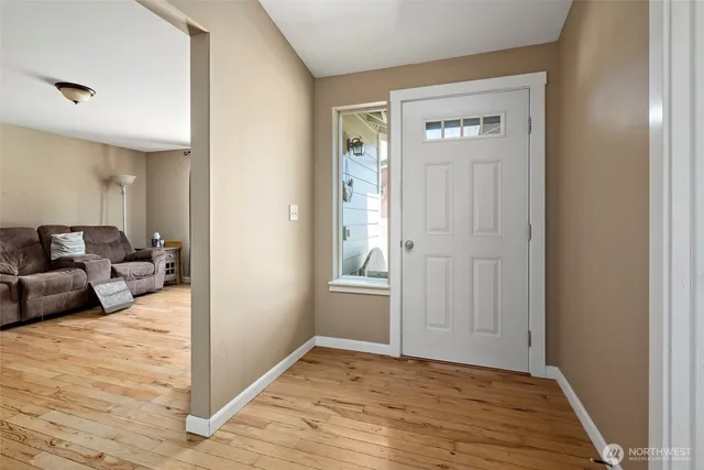 a view of a livingroom with wooden floor and furniture