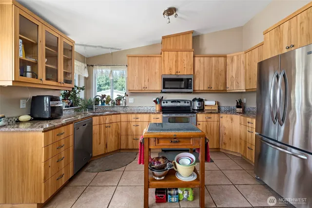 a kitchen with stainless steel appliances granite countertop a refrigerator sink and stove