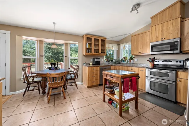 a kitchen with a stove a sink a dining table and chairs