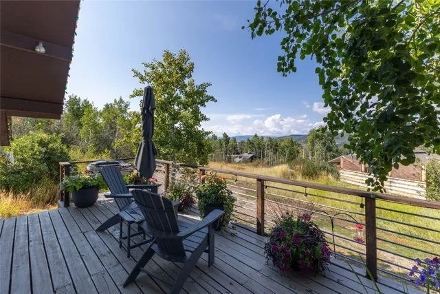 a view of a balcony with chairs and wooden floor