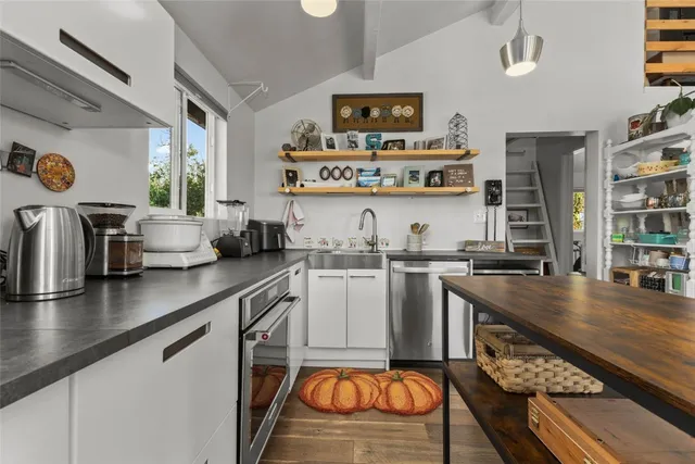 a kitchen with stainless steel appliances kitchen island granite countertop a sink and cabinets