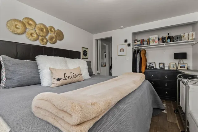 a bedroom with a bed and painting on the wall