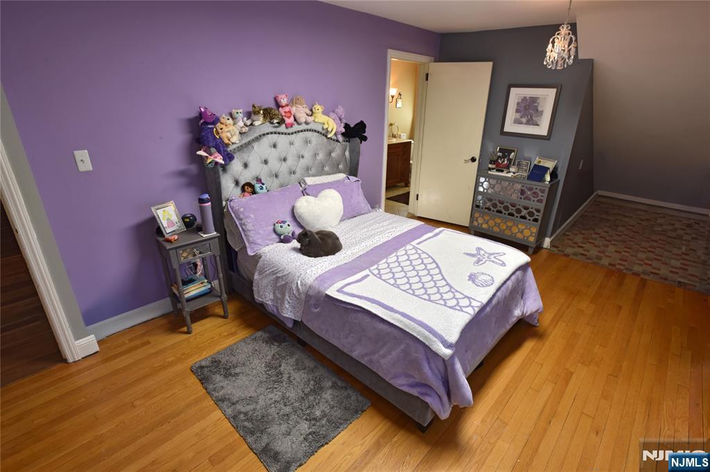 585 Monroe Place Ridgefield, NJ 07657 - Photo 17 of 28 a bed sitting in a bedroom next to a window with chair and dresser