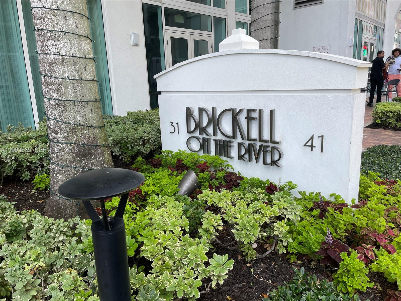 a view of a sign board with potted plants