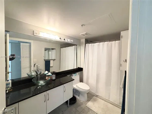 a bathroom with a double vanity sink toilet and a mirror