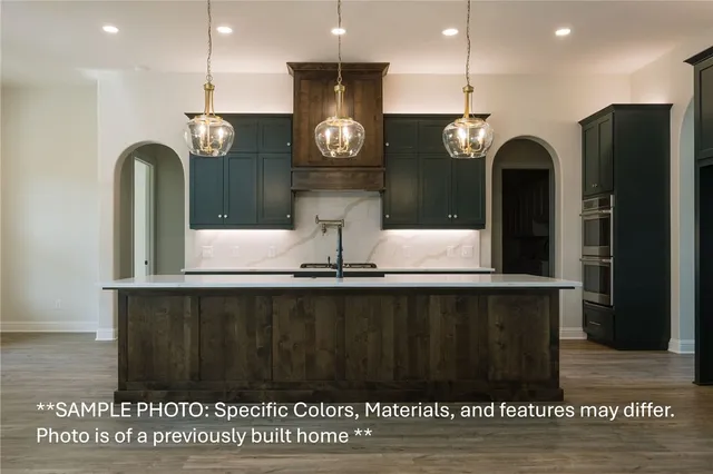 a kitchen with a sink a refrigerator and chairs