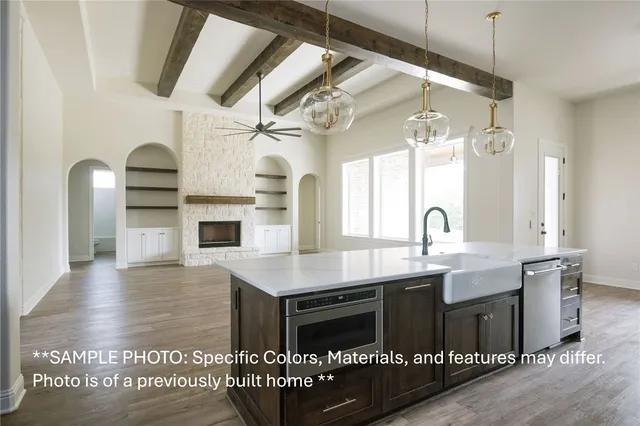 a kitchen with kitchen island granite countertop a stove a sink and a dining table with wooden floor