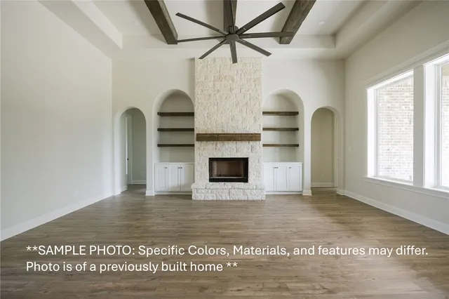 a view of empty room with a fireplace and wooden floor