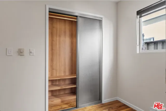 a bedroom with a large bed mirror and window