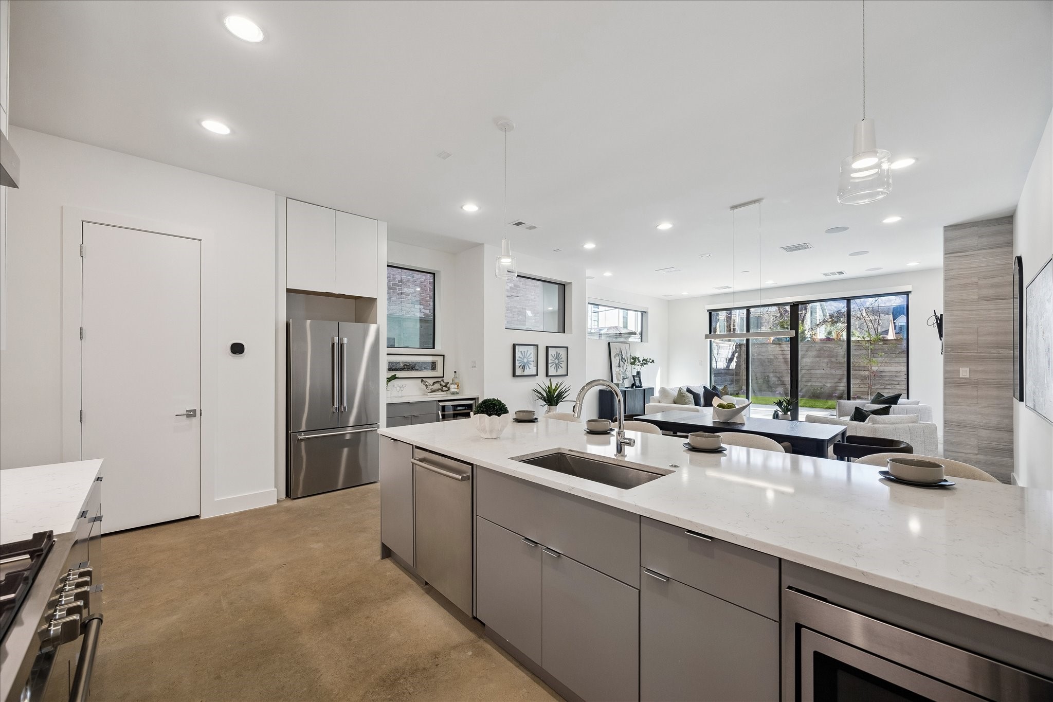 2147 Harold Street Houston, TX 77098 - Photo 12 of 28 Kitchen: Expansive quartz peninsula with ample prep space, complemented by a dedicated pantry and seamless sightlines to the dining and living areas.