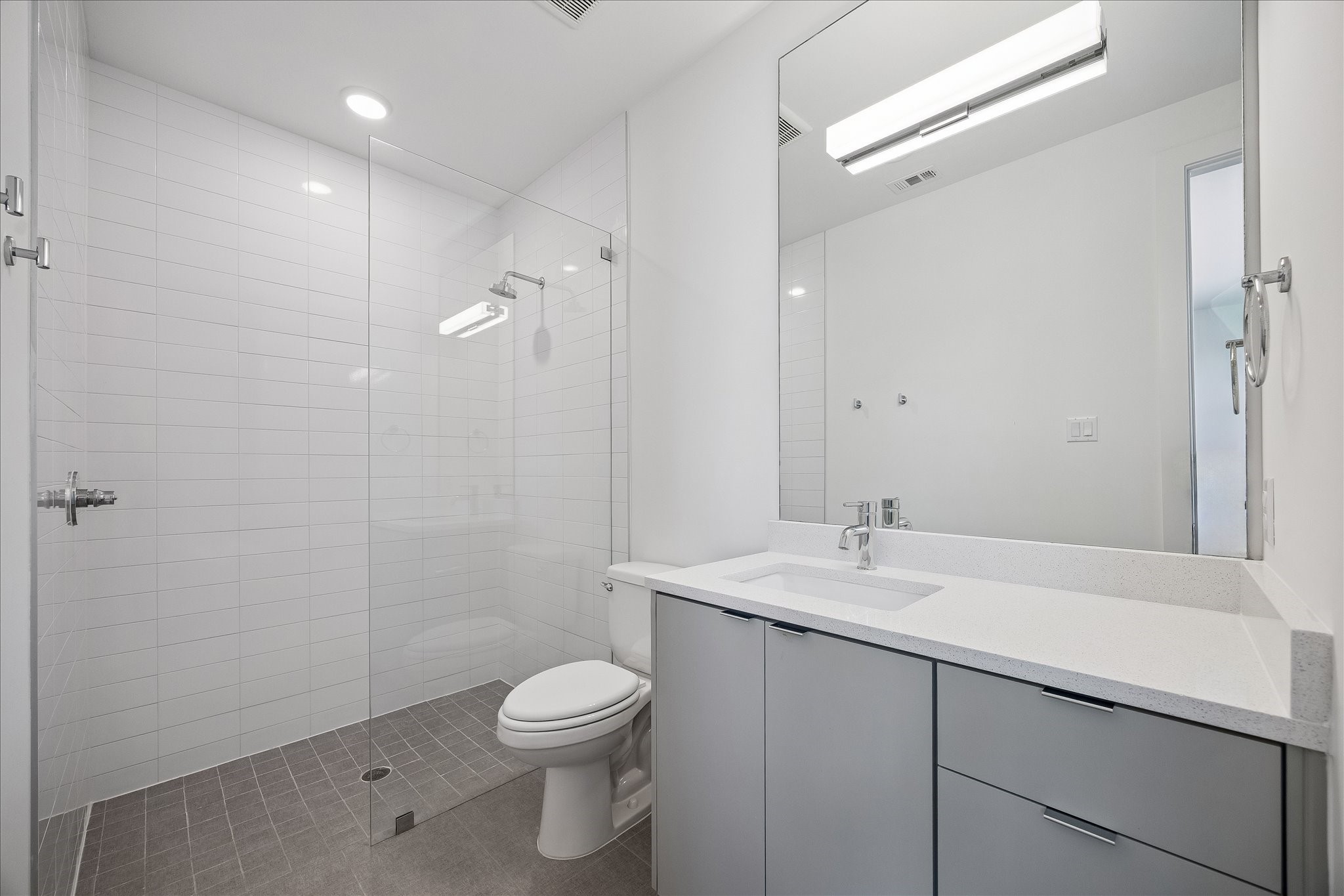 2147 Harold Street Houston, TX 77098 - Photo 21 of 28 Bedroom 2 Ensuite Bathroom-Second Level- Features a sleek vanity with quartz countertops and a glass-enclosed shower with clean, modern tile finishes.