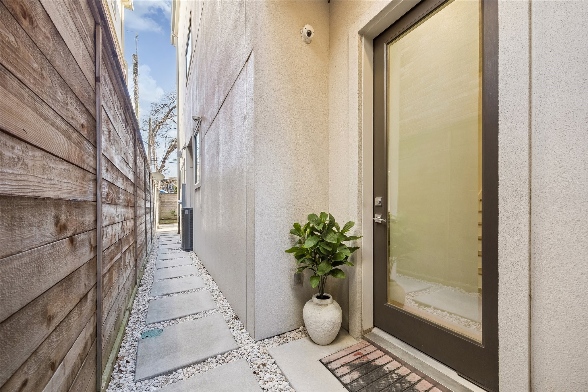 2147 Harold Street Houston, TX 77098 - Photo 3 of 28 Private, gated side entry with a clean-lined walkway, offering a discreet and refined approach to the home’s entrance.