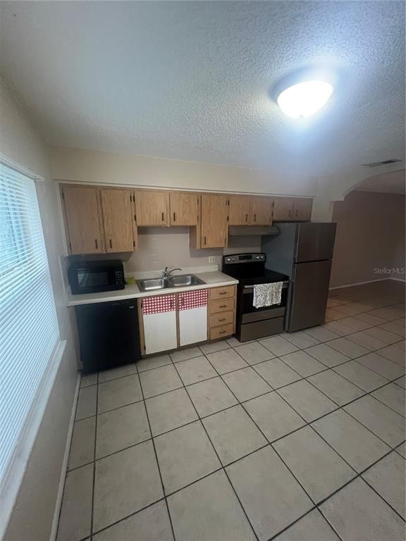 715 Michigan Court, Unit 3 St. Cloud, FL 34769 - Photo 6 of 15 a kitchen with a cabinets a sink and a stove top oven with wooden floor