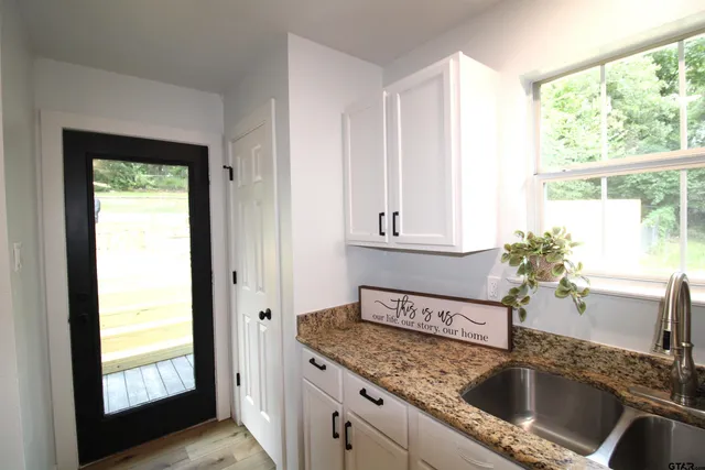 a kitchen with granite countertop a sink and a window