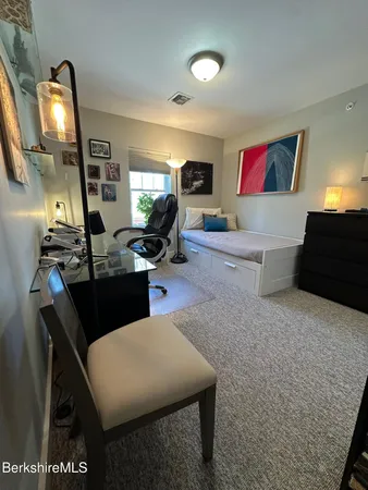 a room with furniture a air conditioner vent and a window