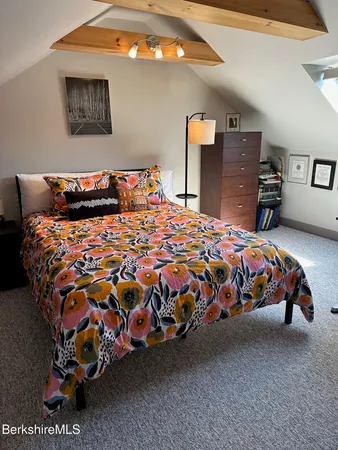 a bedroom with bed and mirror