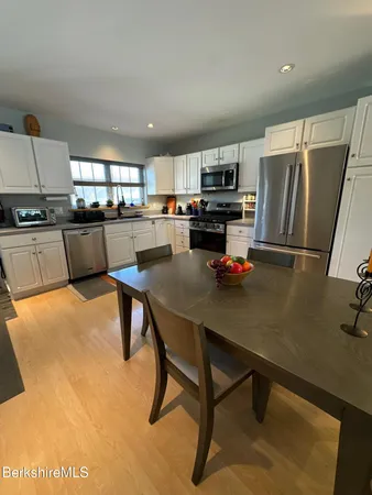 a kitchen with a table chairs and refrigerator