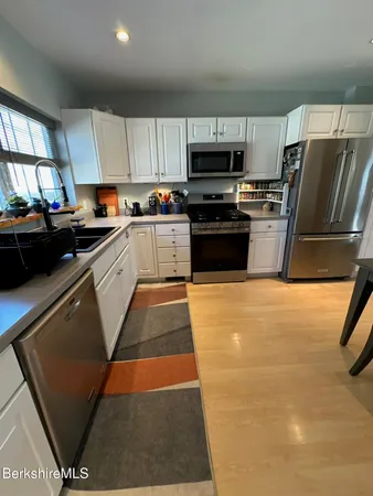 a kitchen with stainless steel appliances granite countertop a refrigerator sink and stove