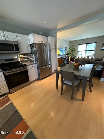 a kitchen with stainless steel appliances kitchen island granite countertop a sink refrigerator and cabinets