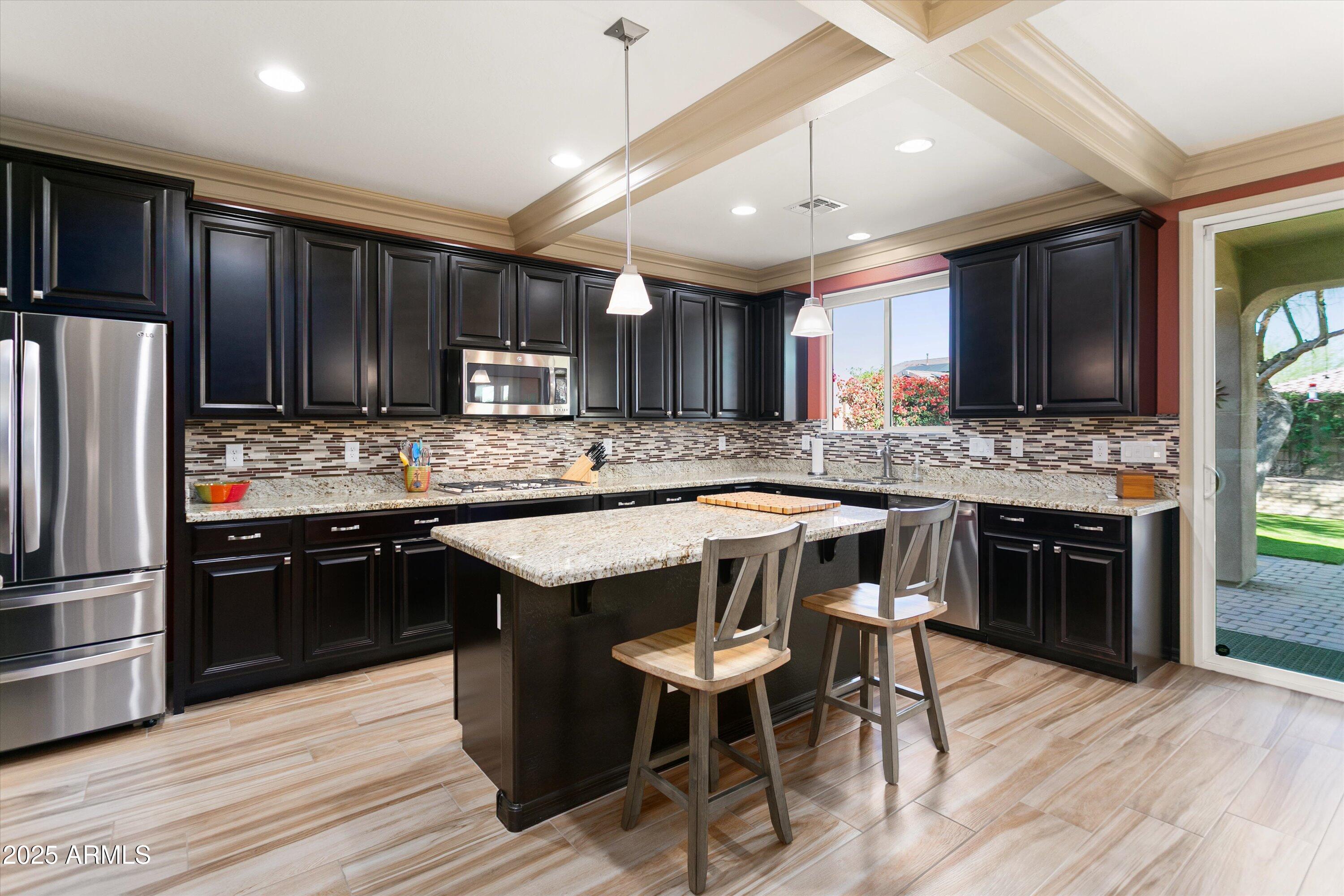 3197 North Springfield Street Buckeye, AZ 85396 - Photo 16 of 60 a kitchen with granite countertop stainless steel appliances and wooden cabinets
