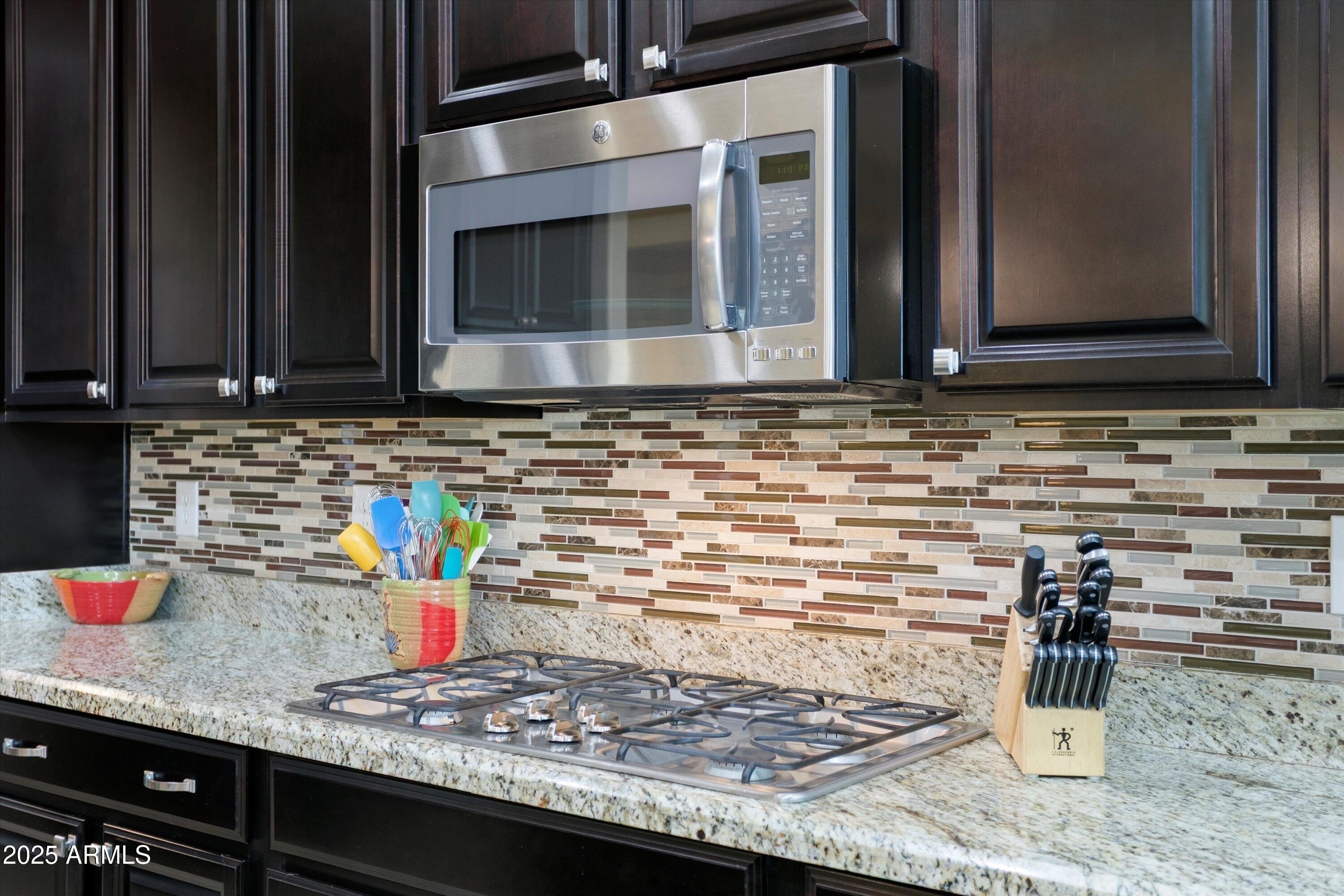 3197 North Springfield Street Buckeye, AZ 85396 - Photo 18 of 60 a kitchen with granite countertop a sink and a stove