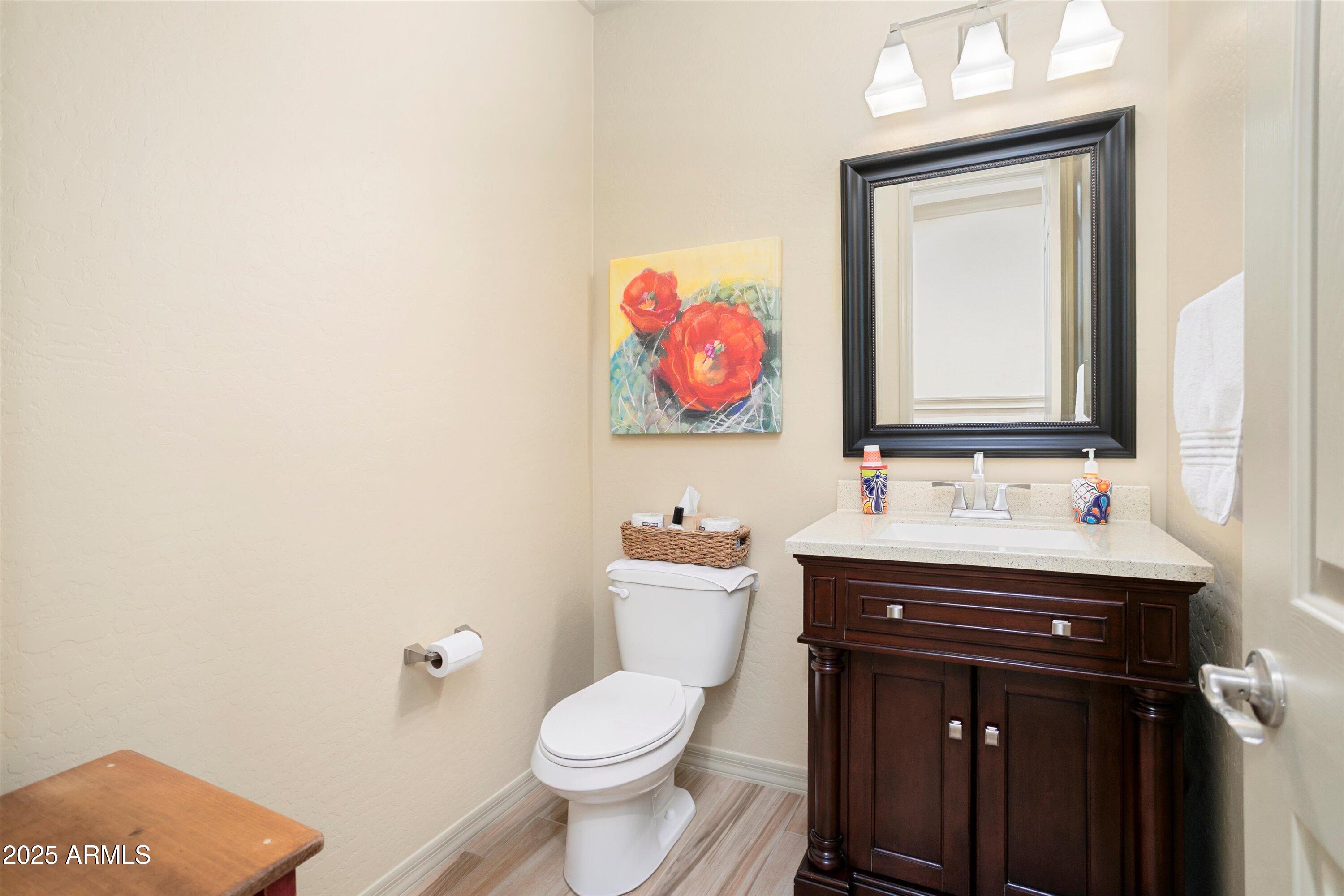 3197 North Springfield Street Buckeye, AZ 85396 - Photo 25 of 60 a bathroom with a toilet sink vanity and mirror
