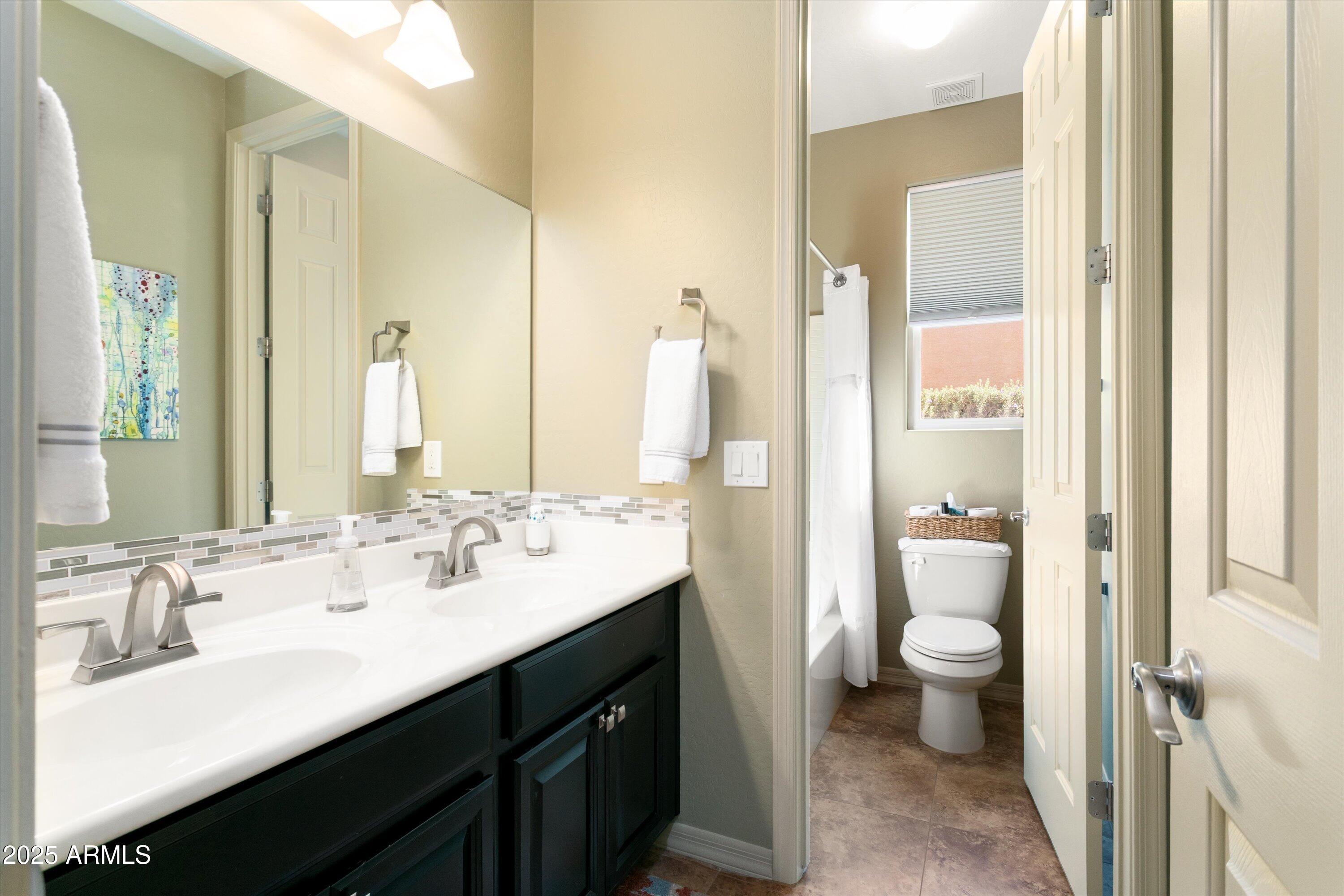 3197 North Springfield Street Buckeye, AZ 85396 - Photo 37 of 60 a bathroom with a double vanity sink toilet and a mirror