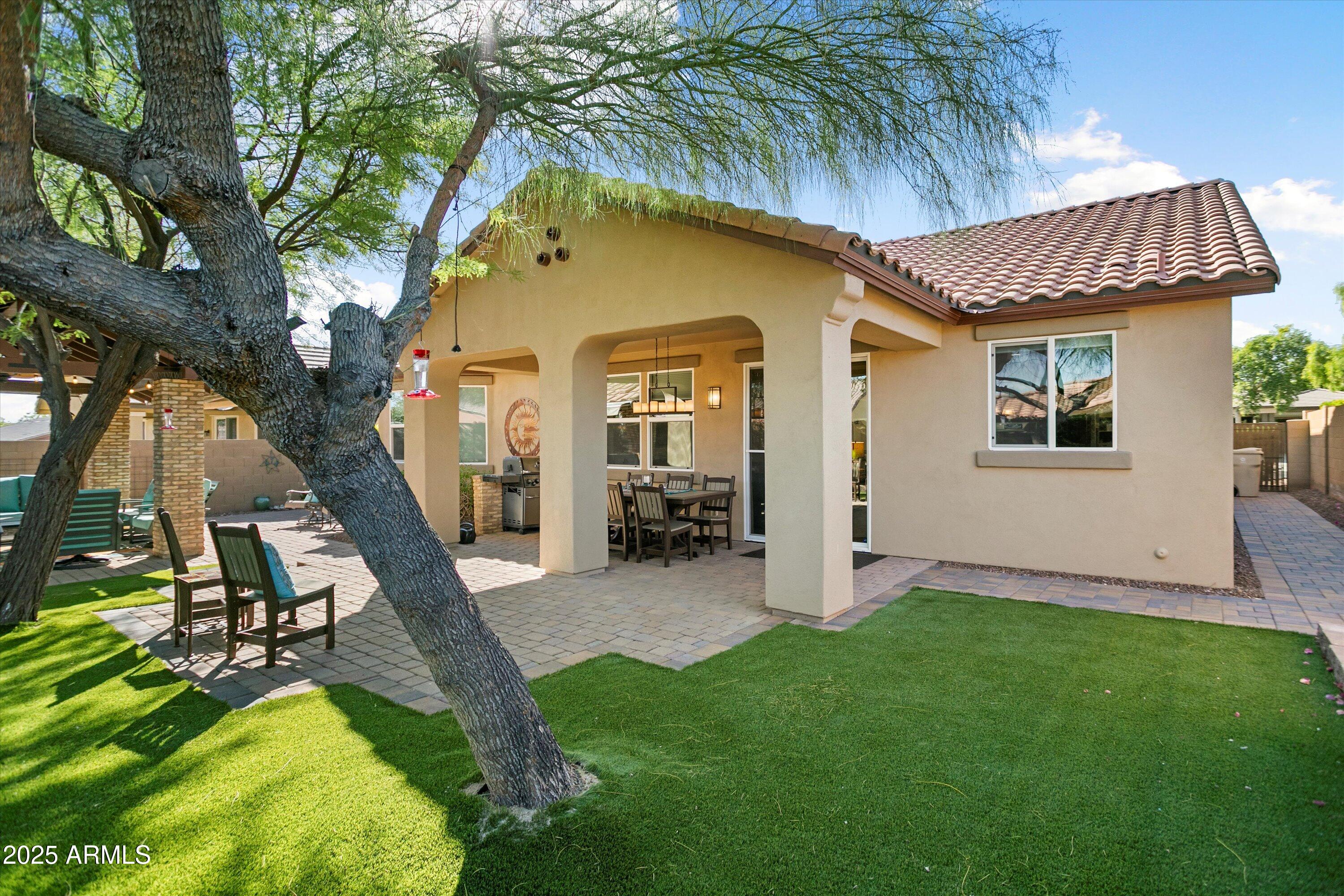 3197 North Springfield Street Buckeye, AZ 85396 - Photo 54 of 60 a view of a house with a yard fire pit and a large tree