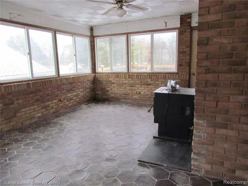 1830 North Eager Road Howell, MI 48855 - Photo 7 of 37 Sun room / Dining with Pellet stove (needs to be hooked up)