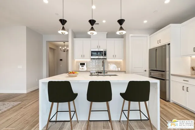 a bedroom with a large bed a chandelier and windows
