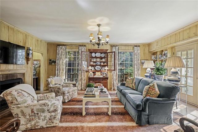 a living room with fireplace furniture and a large window