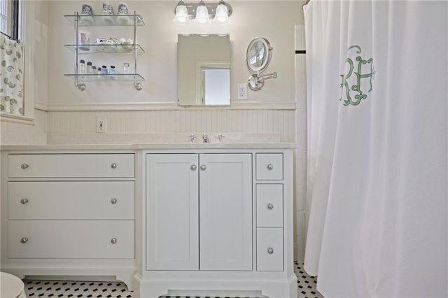 a spacious bathroom with a granite countertop sink mirror vanity and a toilet