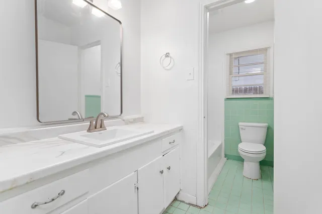 a bathroom with a toilet sink and mirror