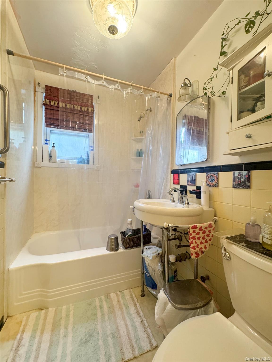 2440 Morgan Avenue Bronx, NY 10469 - Photo 17 of 23 Full bath featuring shower / bathtub combination with curtain, tile walls, and light tile patterned floors