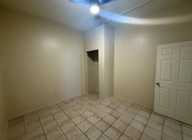 an empty room with a chandelier fan