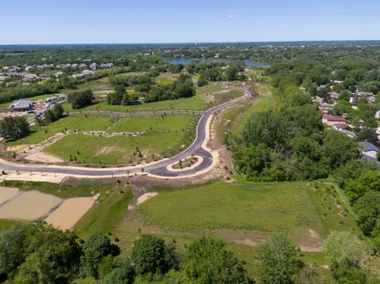an aerial view of residential houses with outdoor space and trees