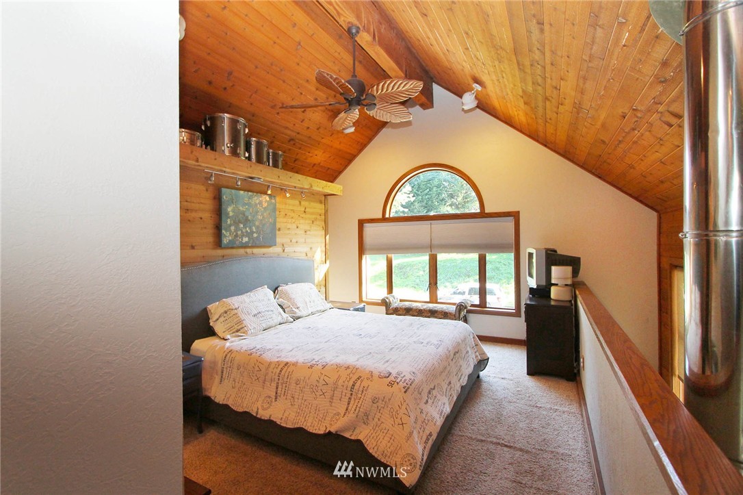 10649 Southwest Cedarhurst Road Vashon, WA 98070 - Photo 12 of 25 a bedroom with a bed and a large window