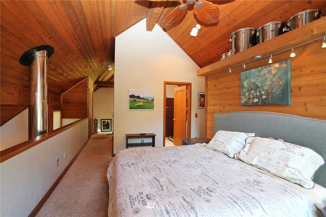 10649 Southwest Cedarhurst Road Vashon, WA 98070 - Photo 13 of 25 a bedroom with a bed and a chandelier