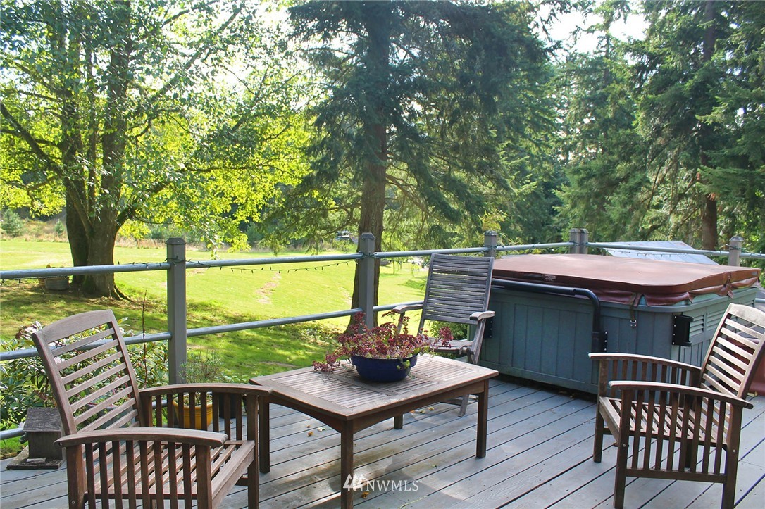10649 Southwest Cedarhurst Road Vashon, WA 98070 - Photo 17 of 25 a view of a balcony with table and chairs and wooden floor