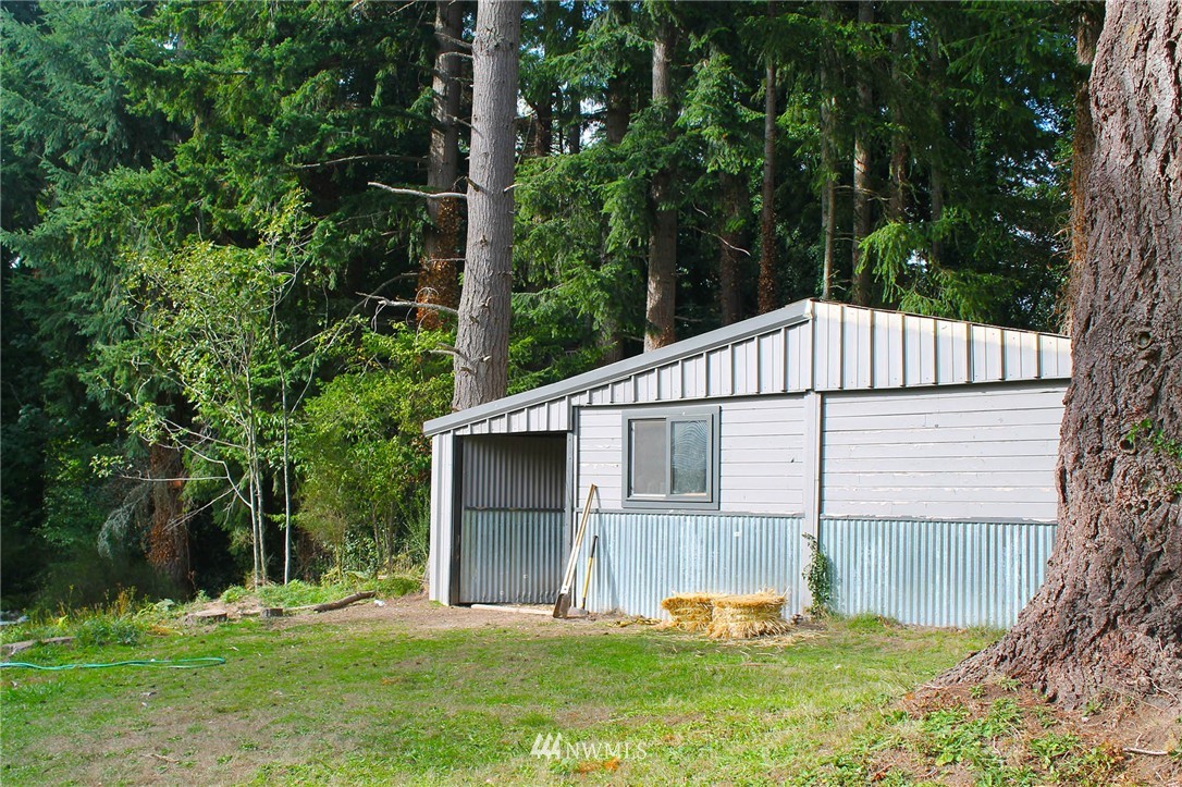10649 Southwest Cedarhurst Road Vashon, WA 98070 - Photo 24 of 25 a white house with green field in front of it