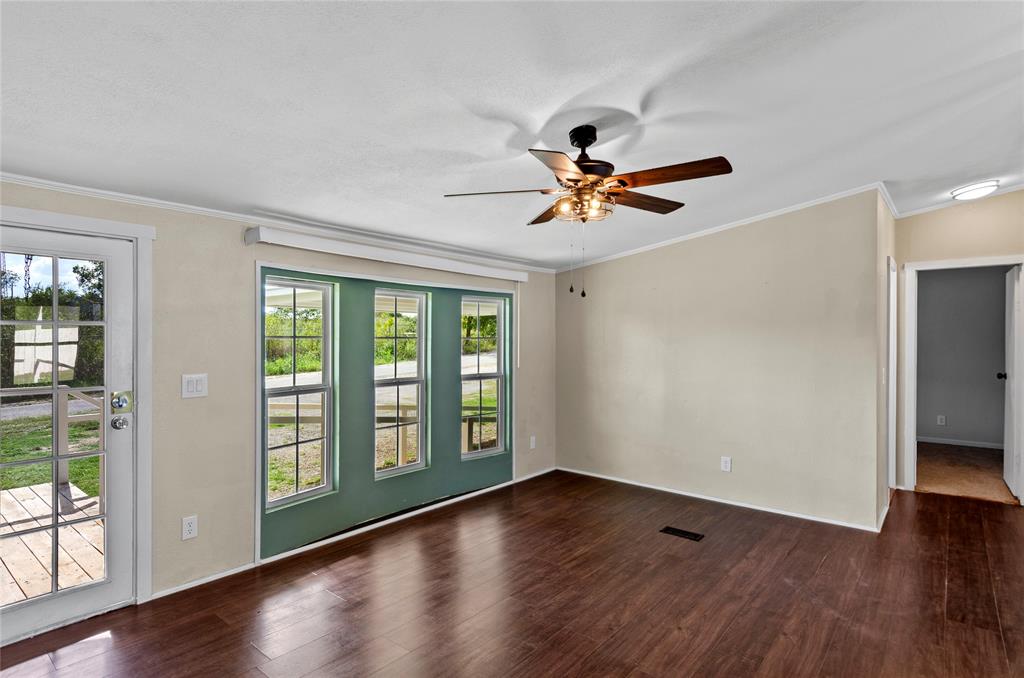 401 Barker Street Bowie, TX 76230 - Photo 7 of 24 a view of room with wooden floor and a ceiling fan