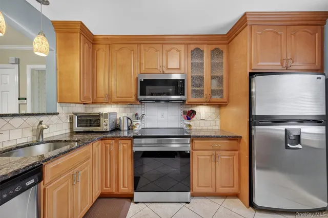 a kitchen with stainless steel appliances granite countertop a stove top oven a sink dishwasher and a microwave oven on the blue kitchen countertops