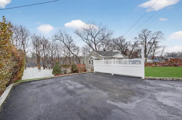 a view of white house with a yard and large trees