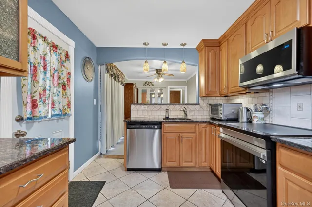 a kitchen with stainless steel appliances granite countertop a sink and a stove