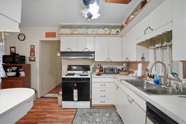 a kitchen with a sink dishwasher a stove and a refrigerator with wooden floor